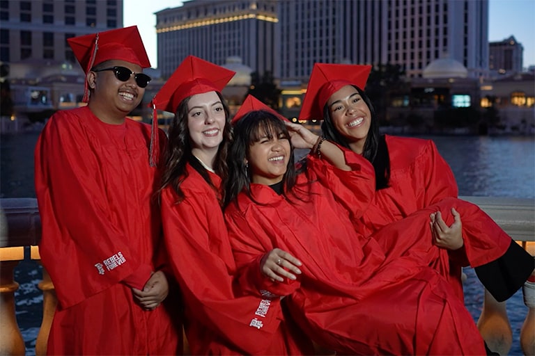 A group of student pose in commencement caps and gowns
