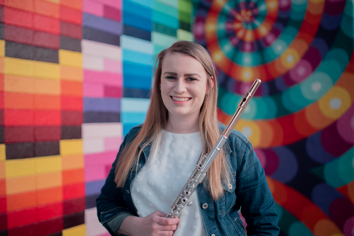 Lauren Zwonik holding her flute and smiling