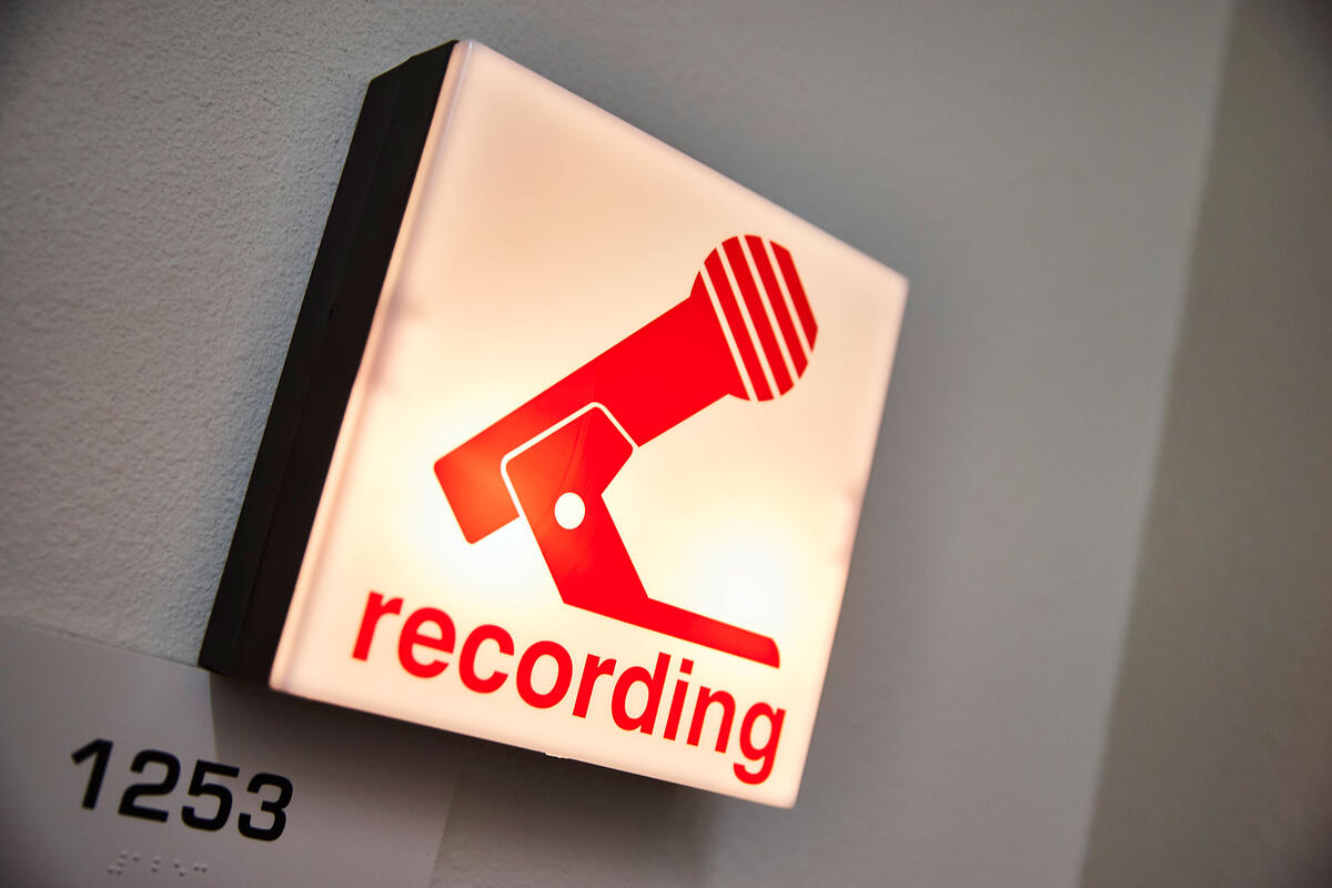 A &quot;recording&quot; sign with a microphone icon.