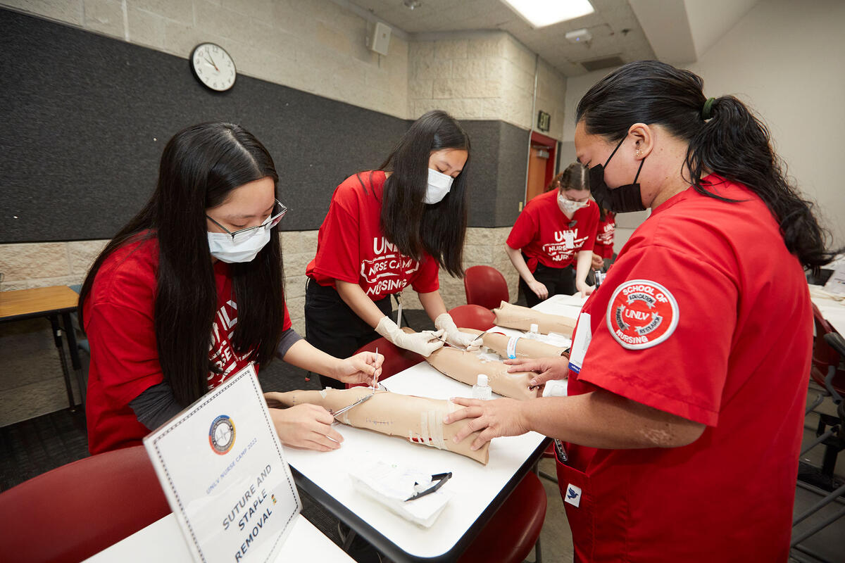 A group of students participating in a suture and staple removal workshop