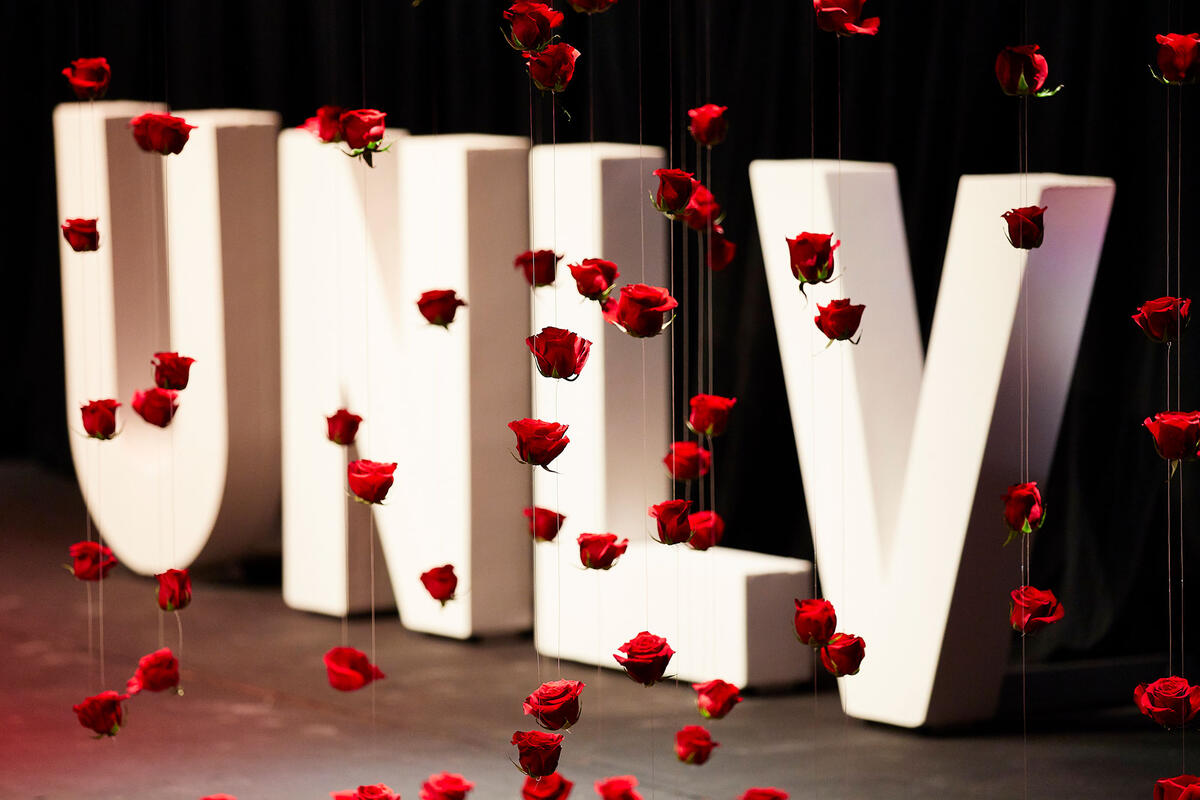 Large standing letters that spells out U-N-L-V on stage with red petals falling down.
