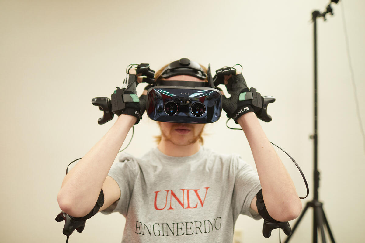 unlv engineering student wearing vr headset and hand equipment