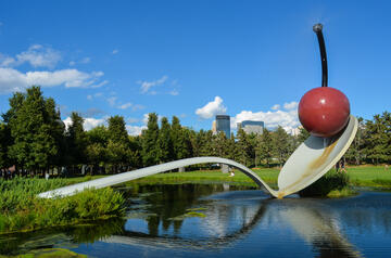 large sculpture of a spoon holding a cherry