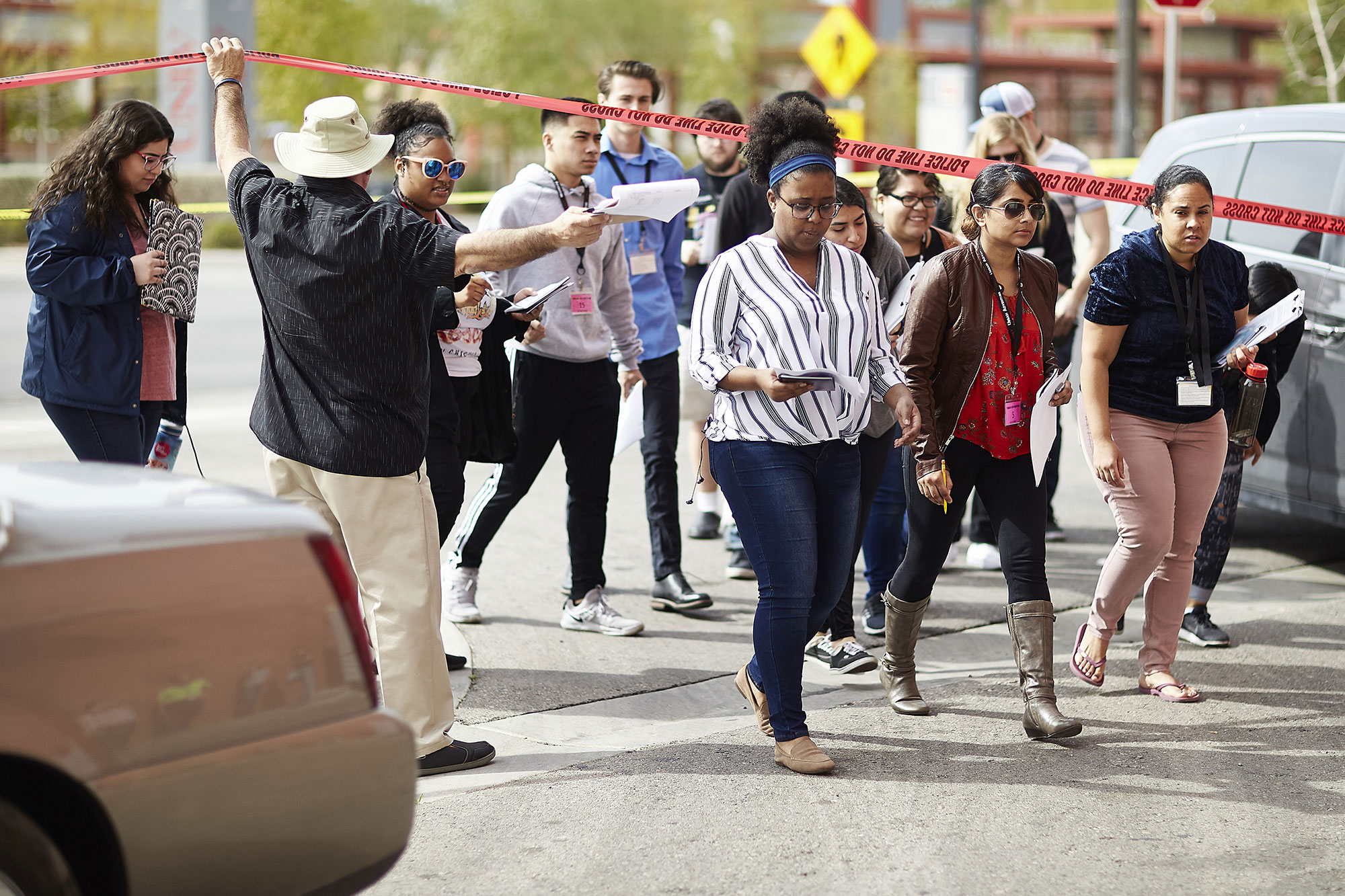 Group of students walking under police tape