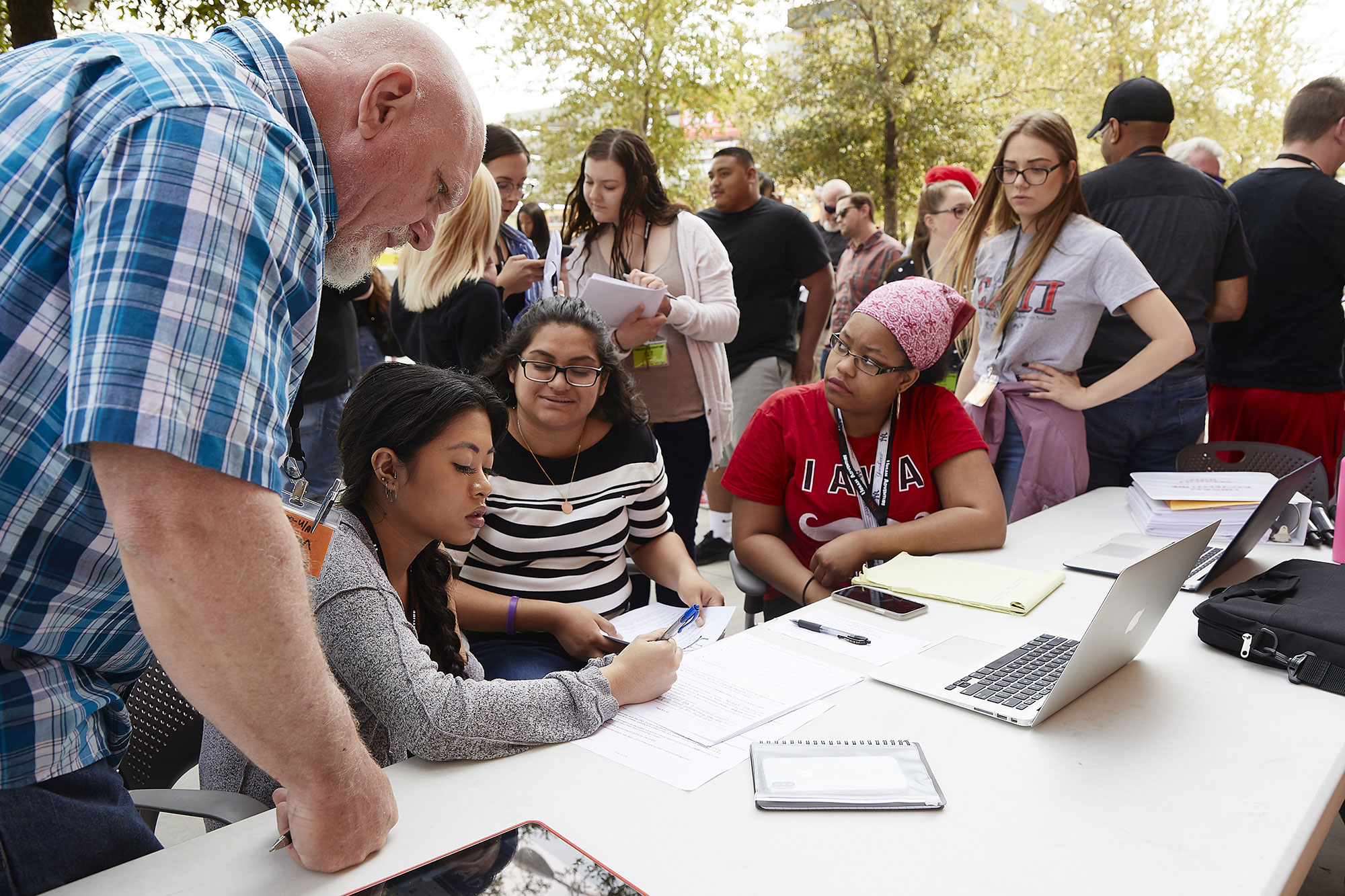 A group of students and an older man gathered around a table