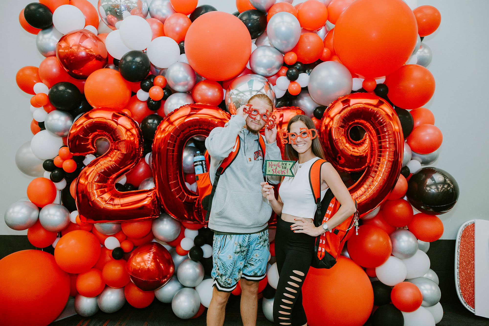 Students at Senior Send off with novelty glasses in front of balloons