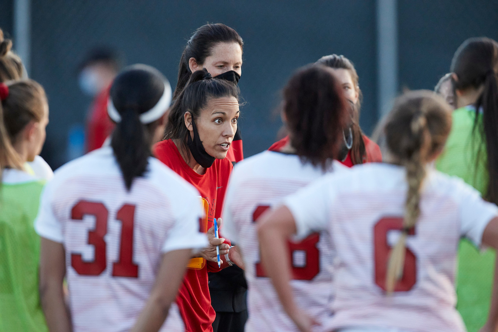 Women's soccer coach talking to her team