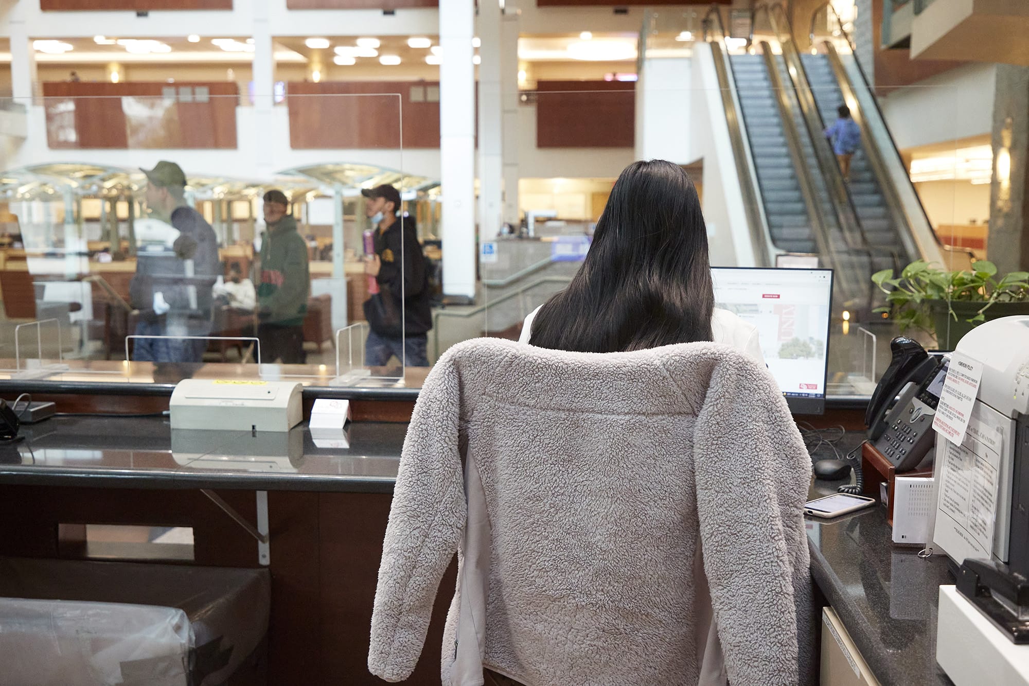 Student employee Elaiza Suarez working on the front desk computer inside the Lied Library