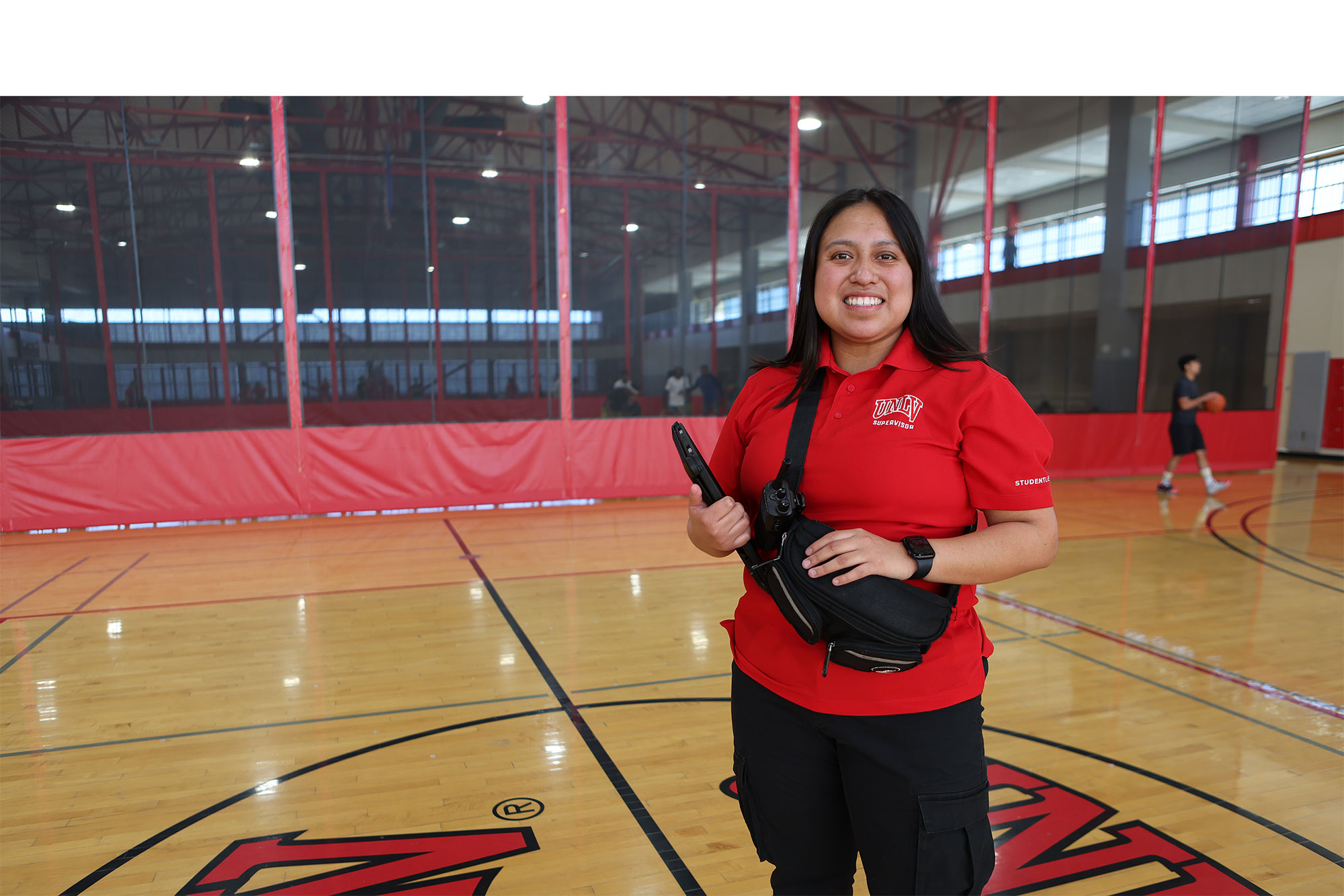 Woman with UNLV shirt standing in the middle of a basketball court