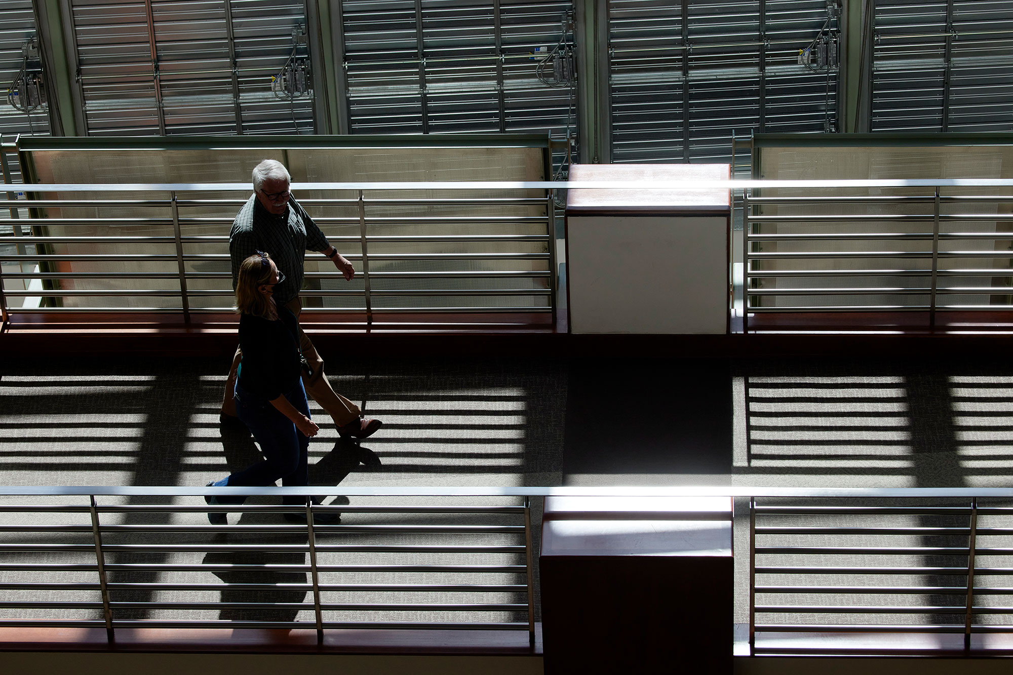 Two people walking on a footbridge