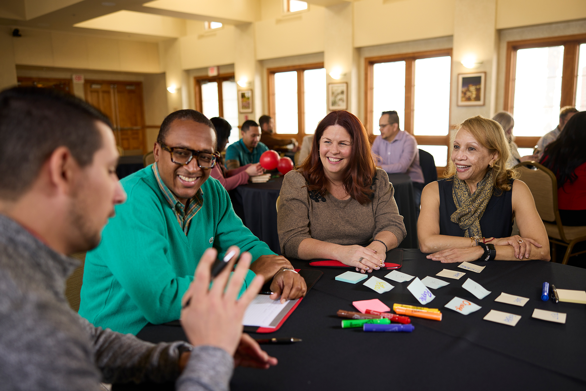 four people discussing at table with sticky notes and highlighters