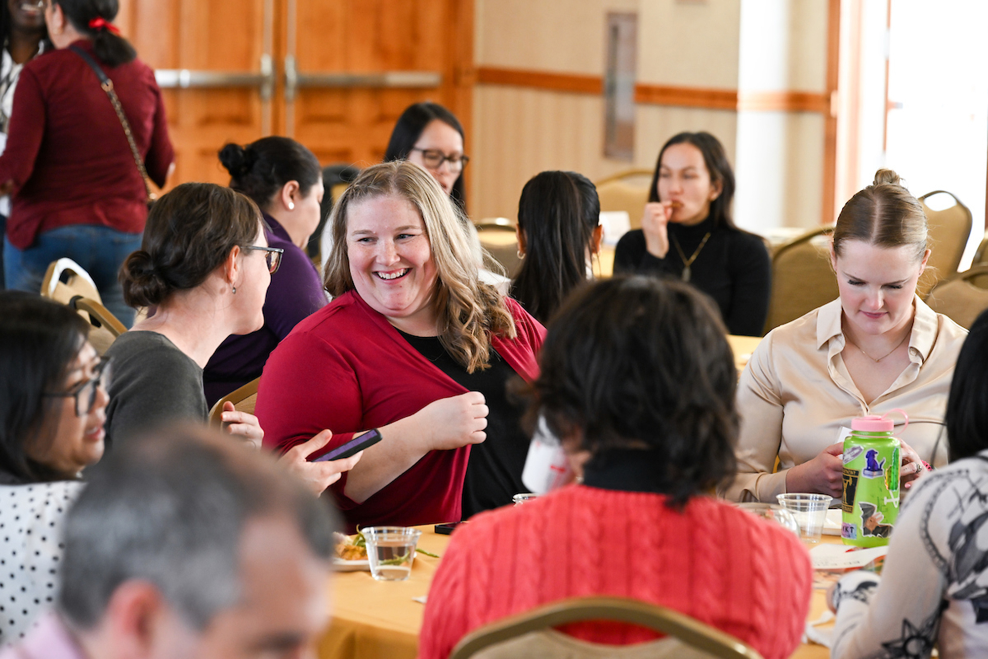 group of women talking and eating at a banquet table