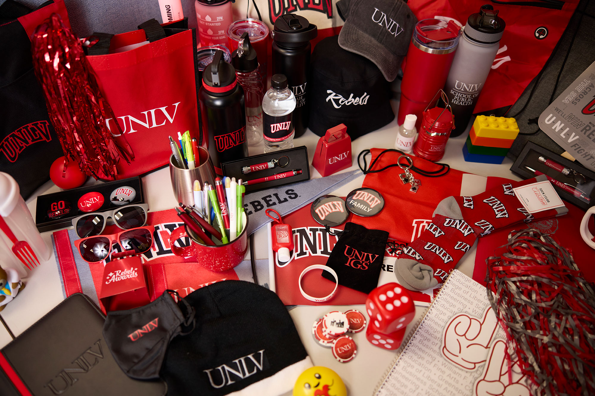 U-N-L-V branded swag including hats, bags, notepads, water bottles, glasses