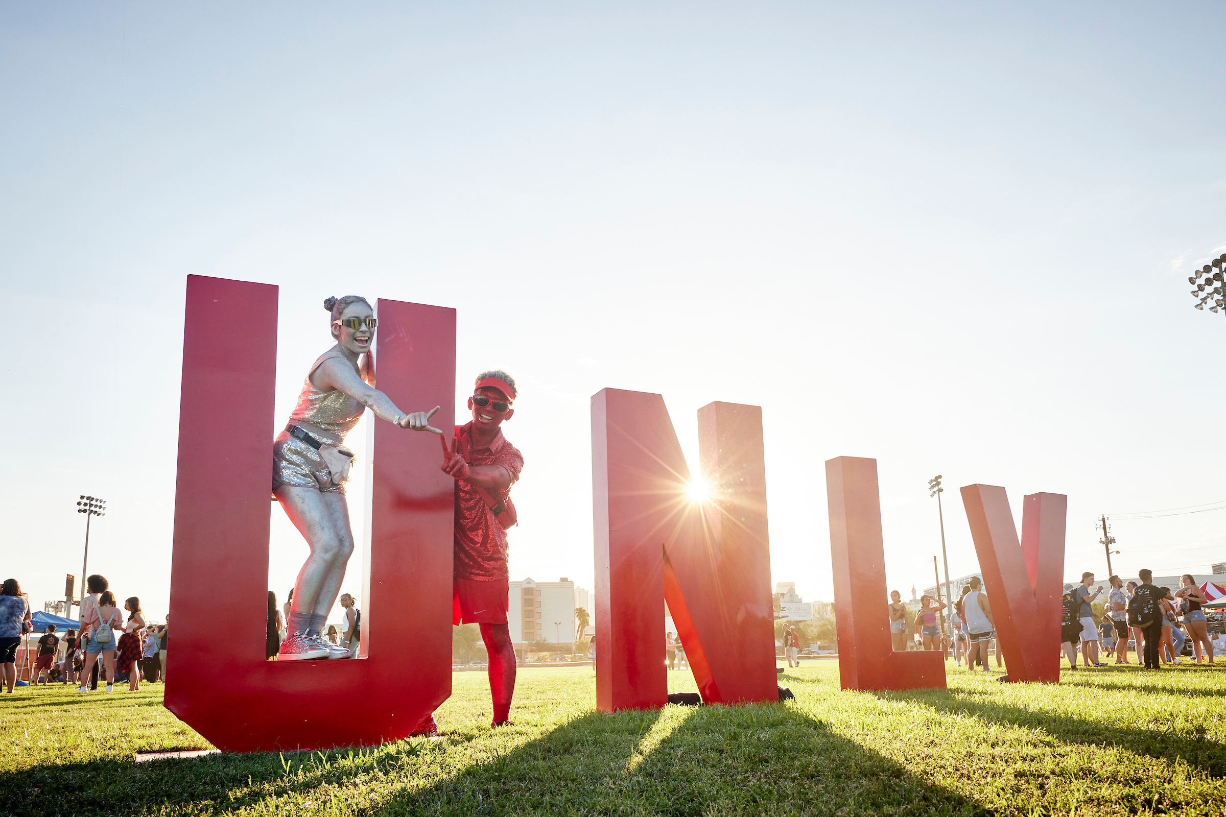 Two people posing for a photo with the letters U-N-L-V