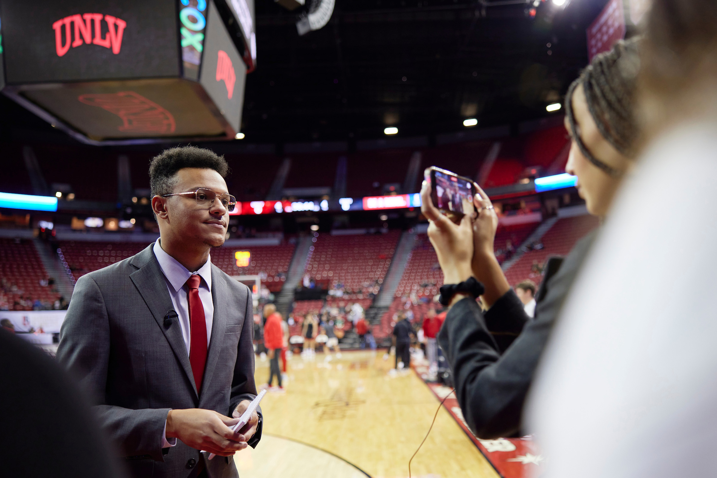 a person being interviewed inside a basketball stadium