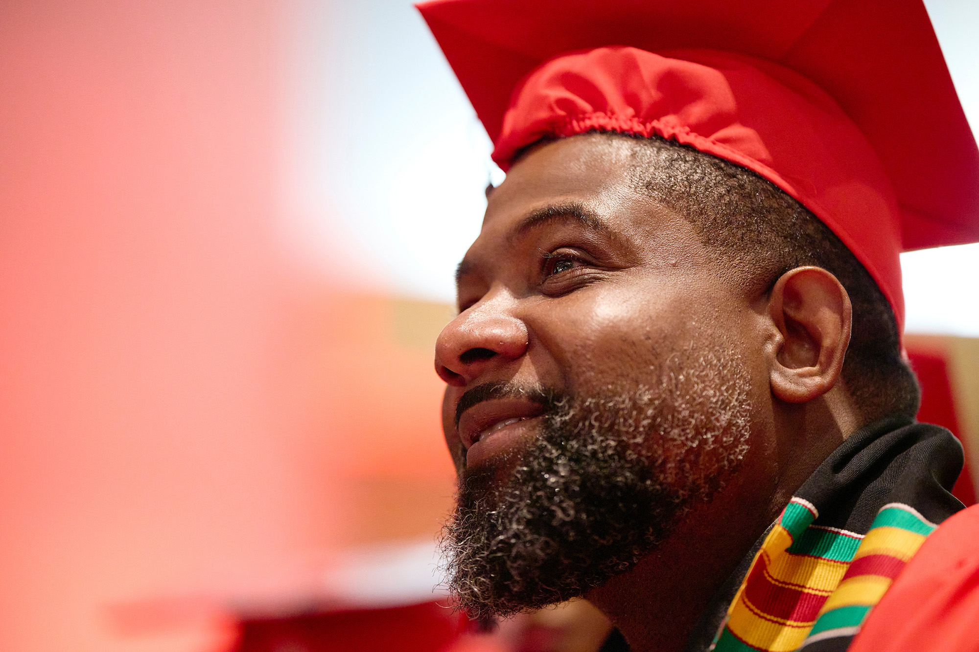 Portrait of man looking up with graduation cap on