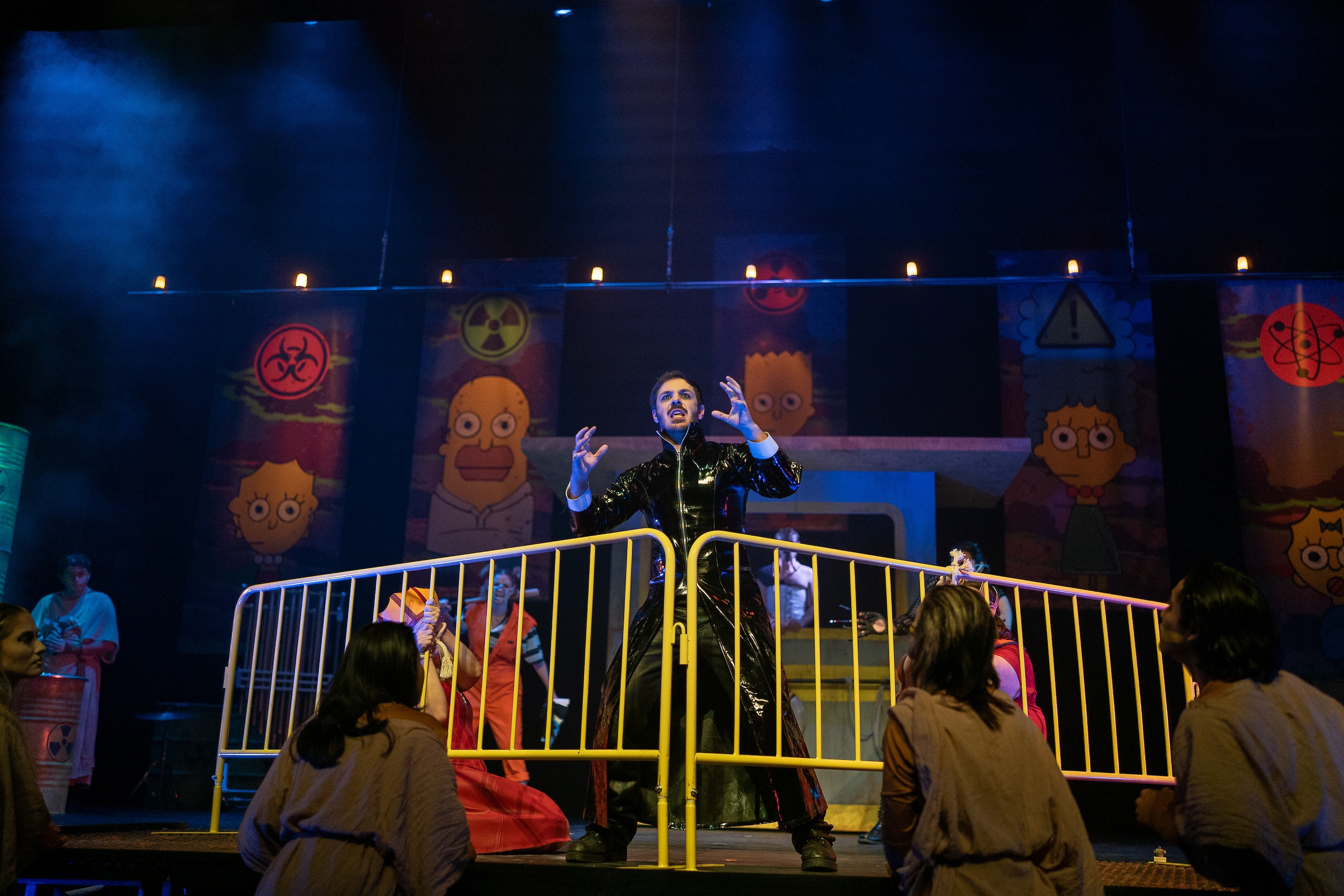 Person in black cat suit behind blockade on stage.