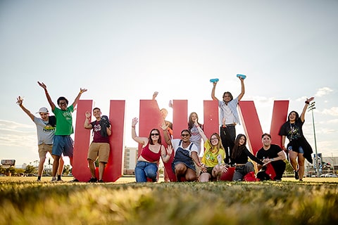 A group of students pose in front of U.N.L.V. letters