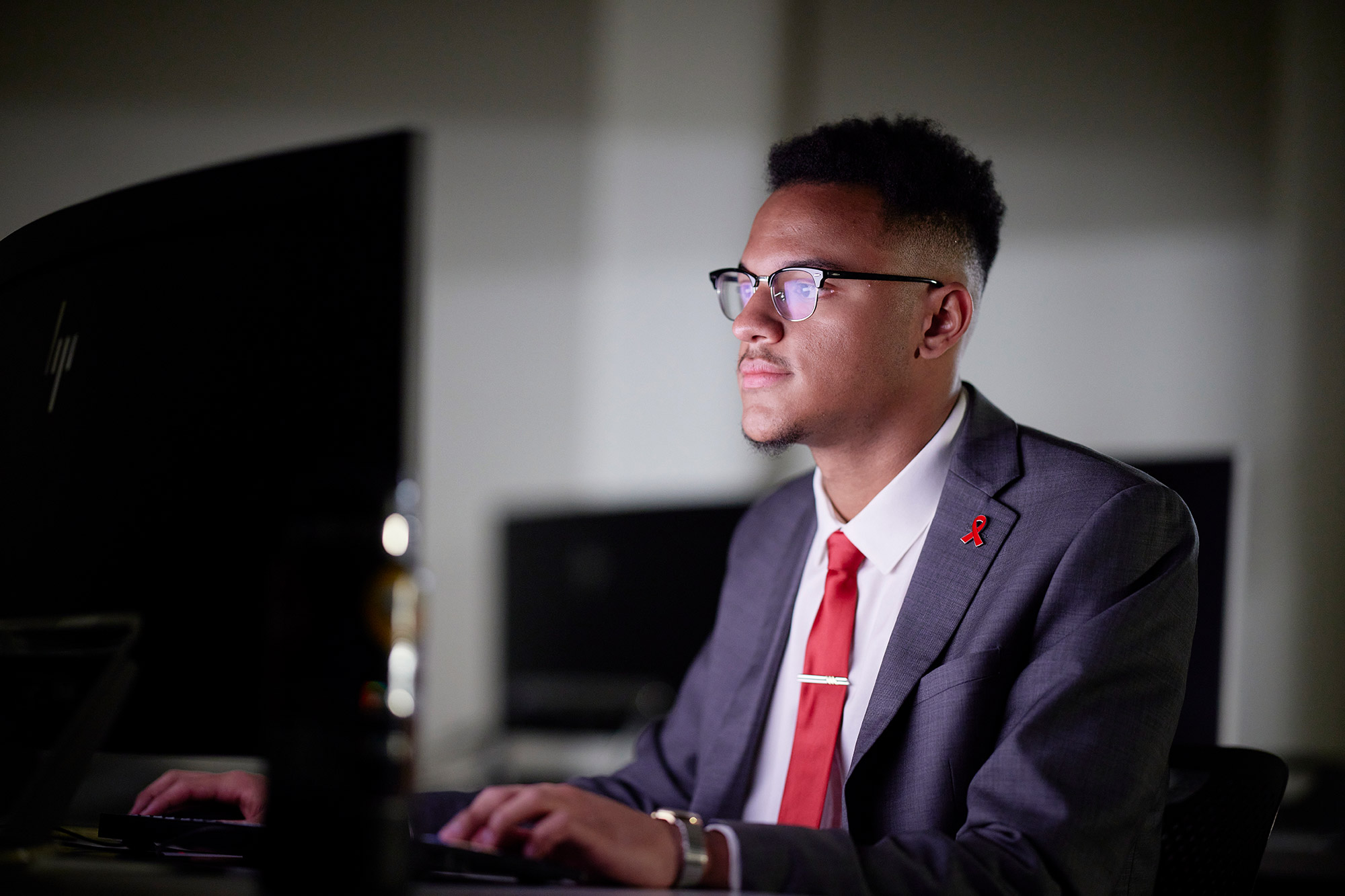 A man with glasses looking at a computer screen