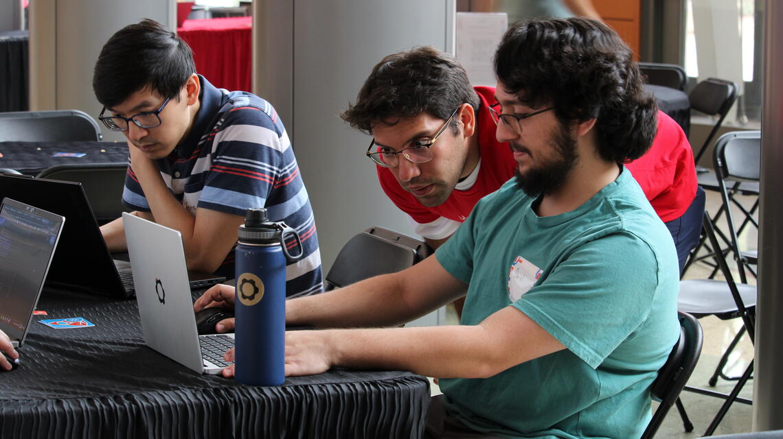 Three people work on laptops