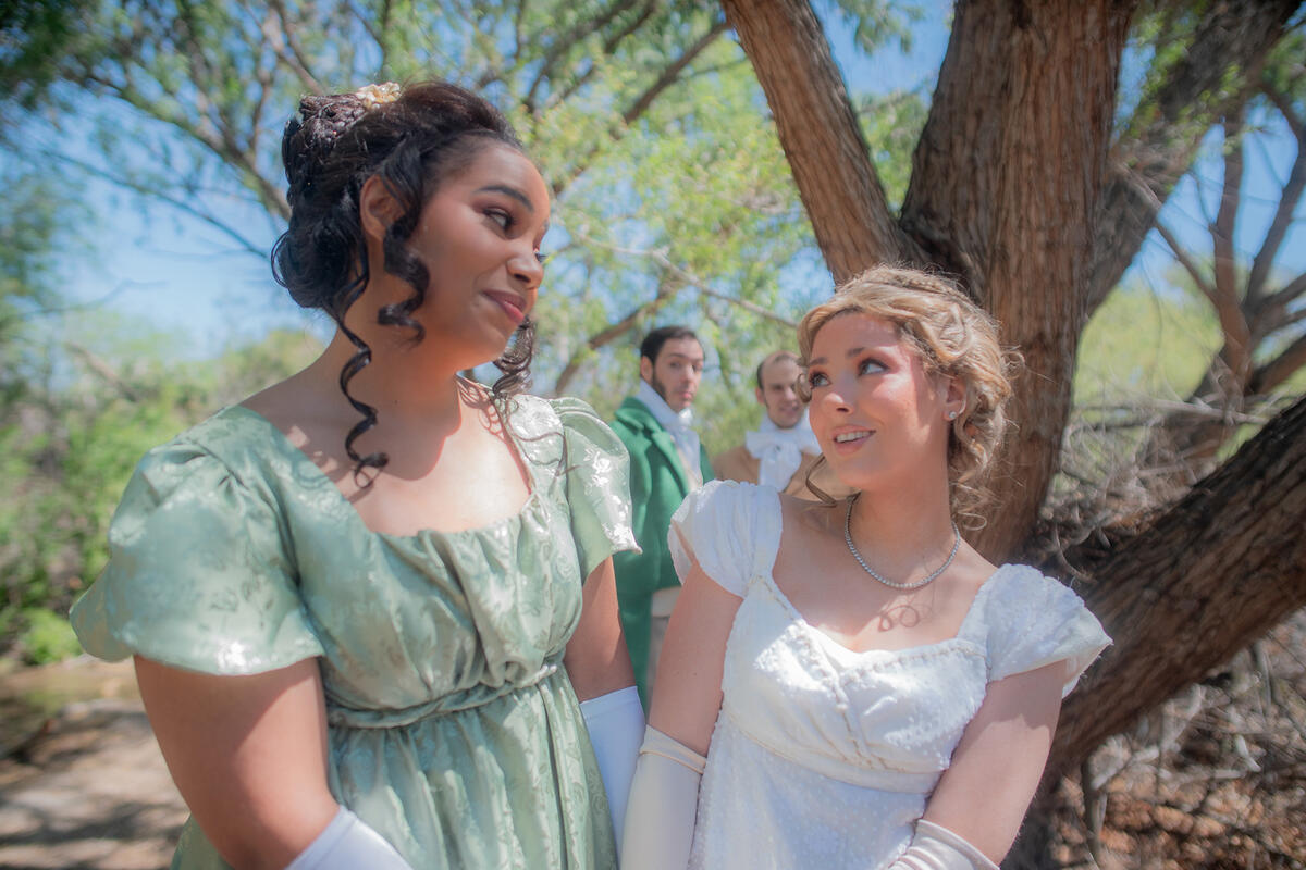 Two women dressed like princesses looking at each other