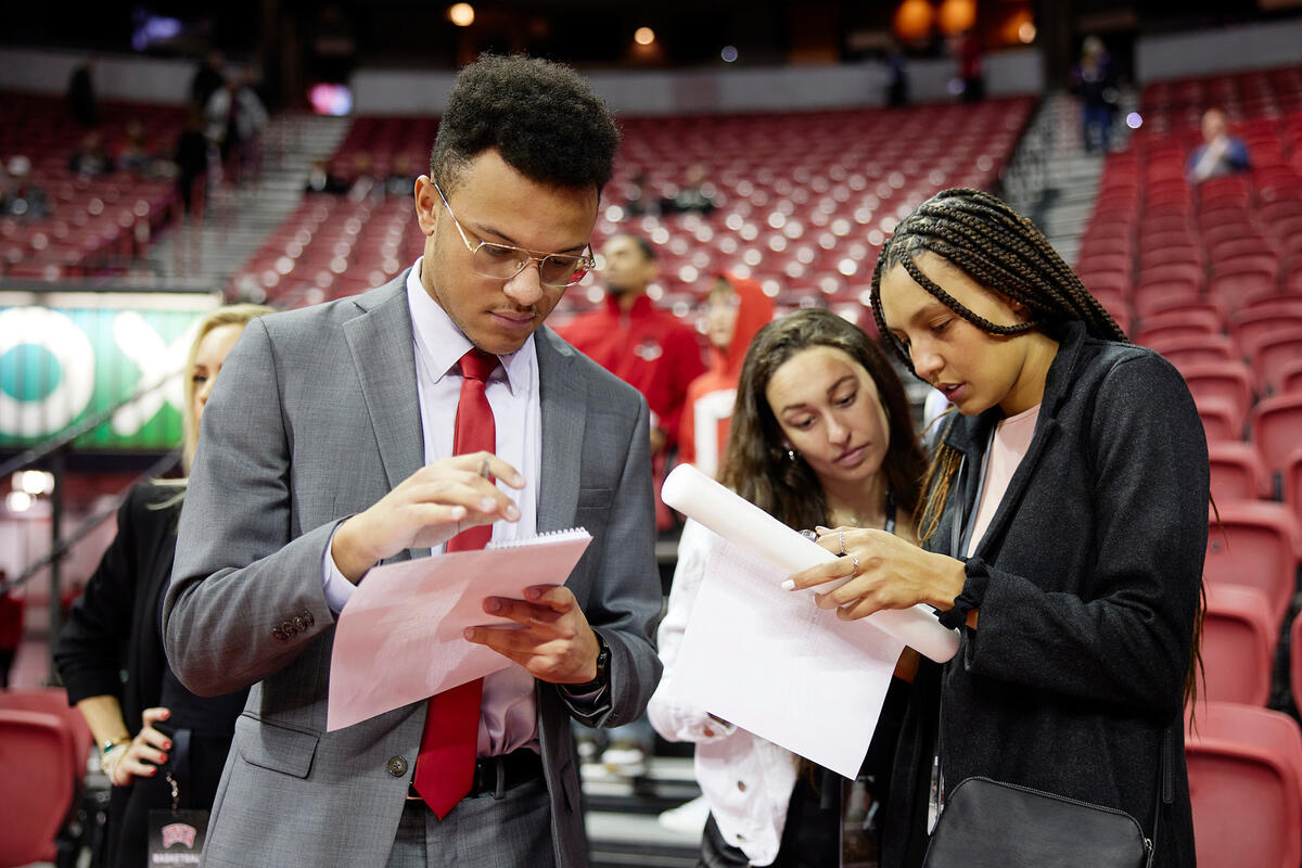 three people in suits looking at files