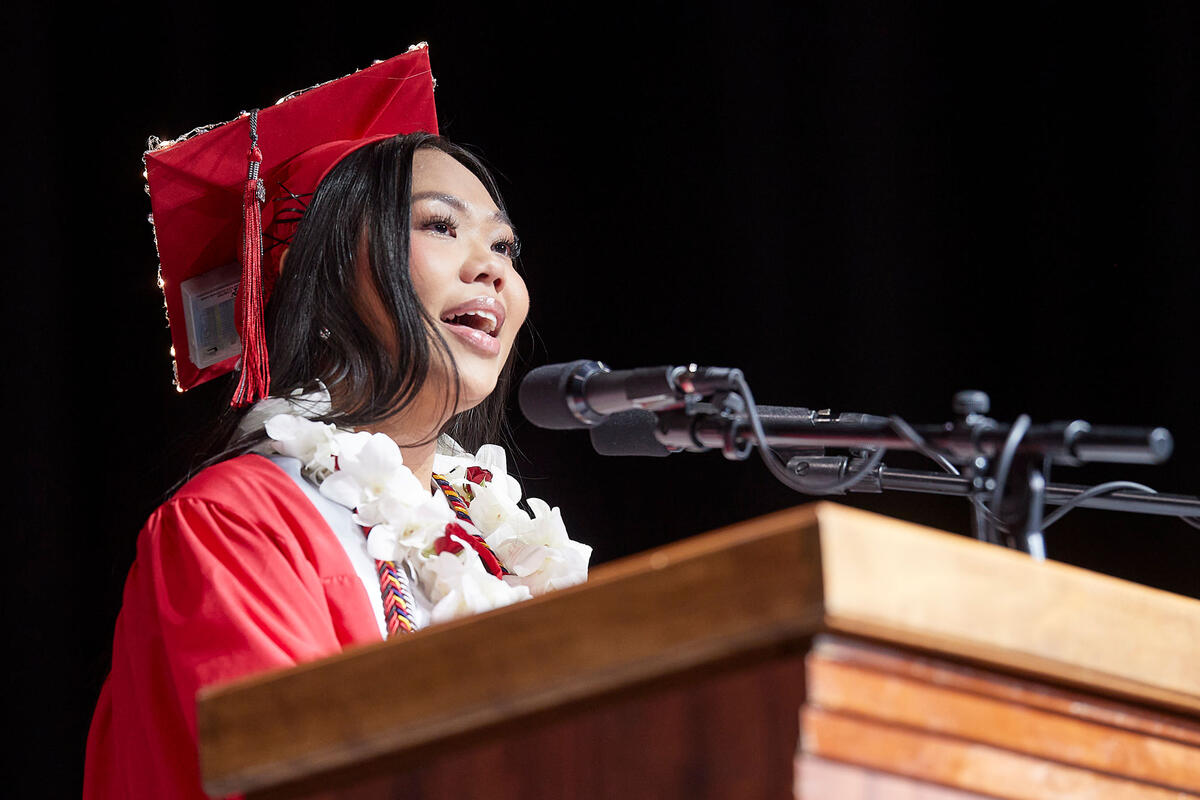 A woman speaking at a podium at a graduation