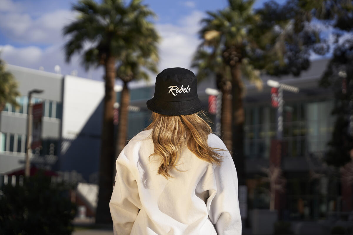 Back of a person wearing a black hat with REBELS