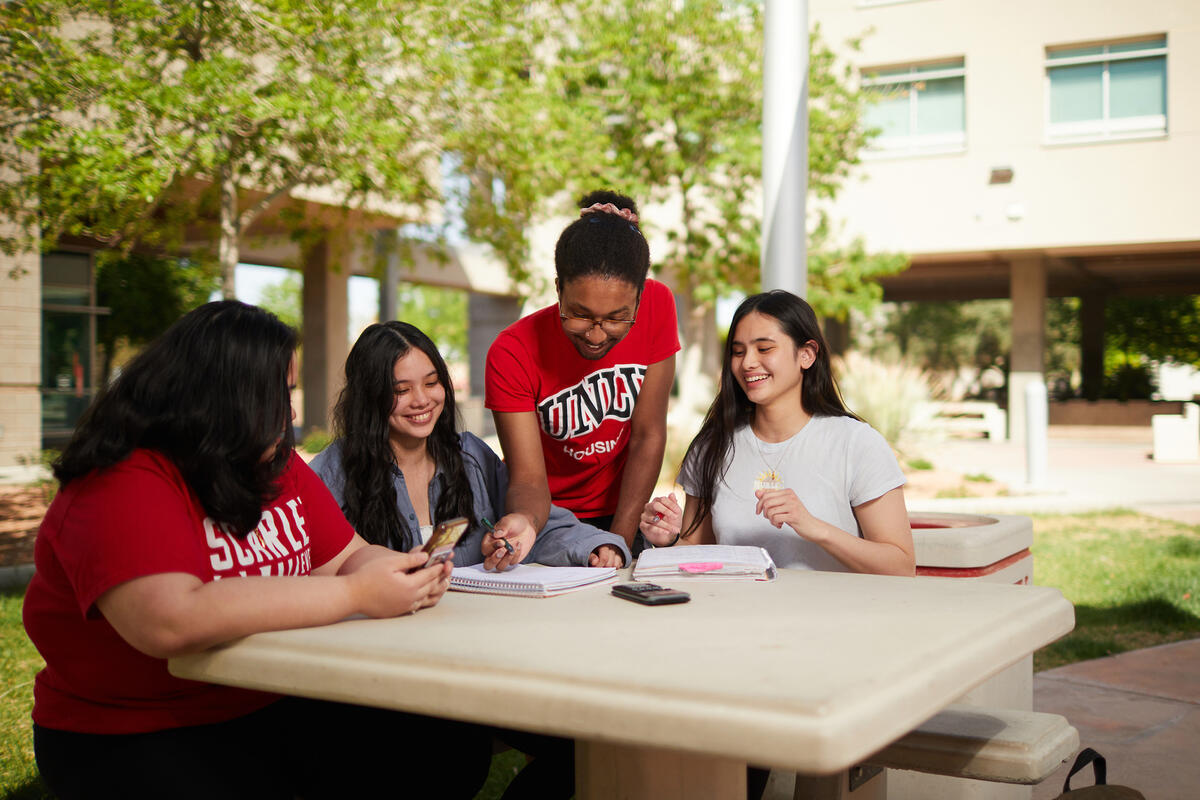 Four students sitting in an outdoor table