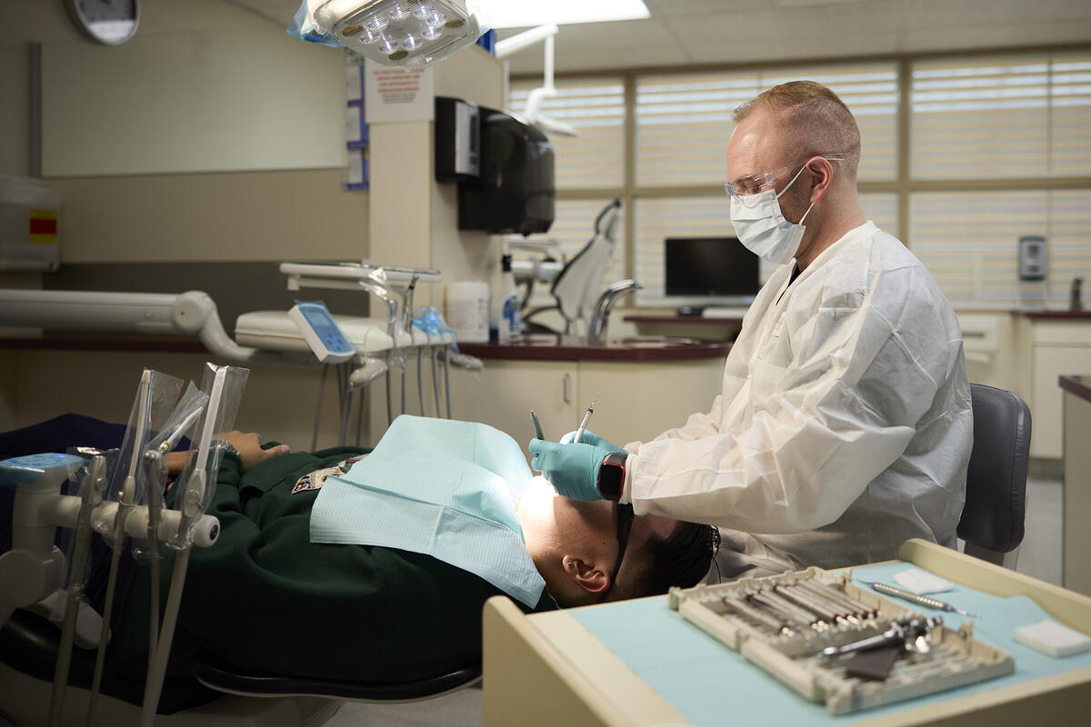 A dentist doing an oral exam on a patient