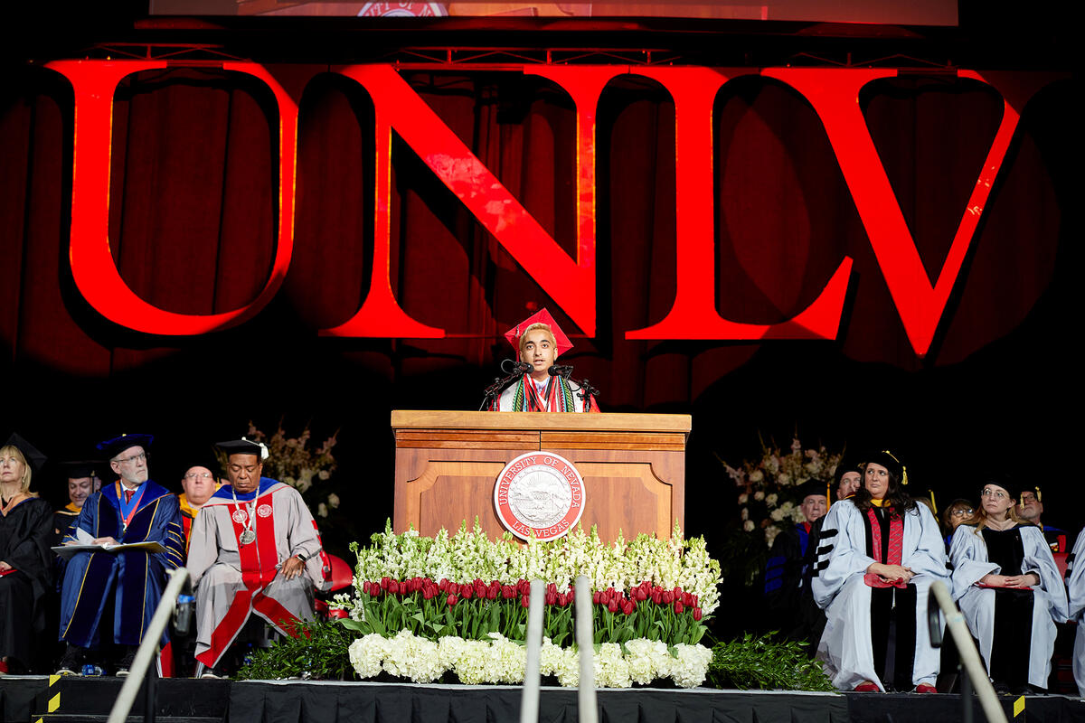 Student standing on podium giving speech during graduation