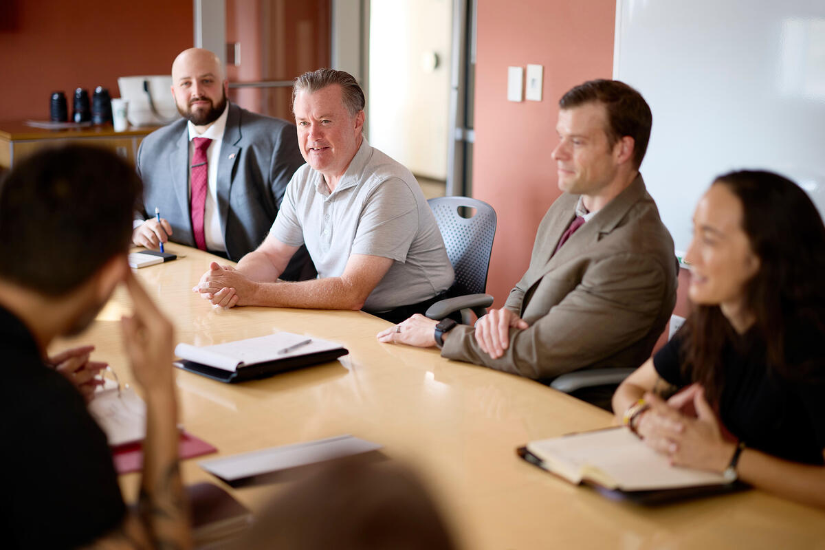 a group of people sitting in a meeting table