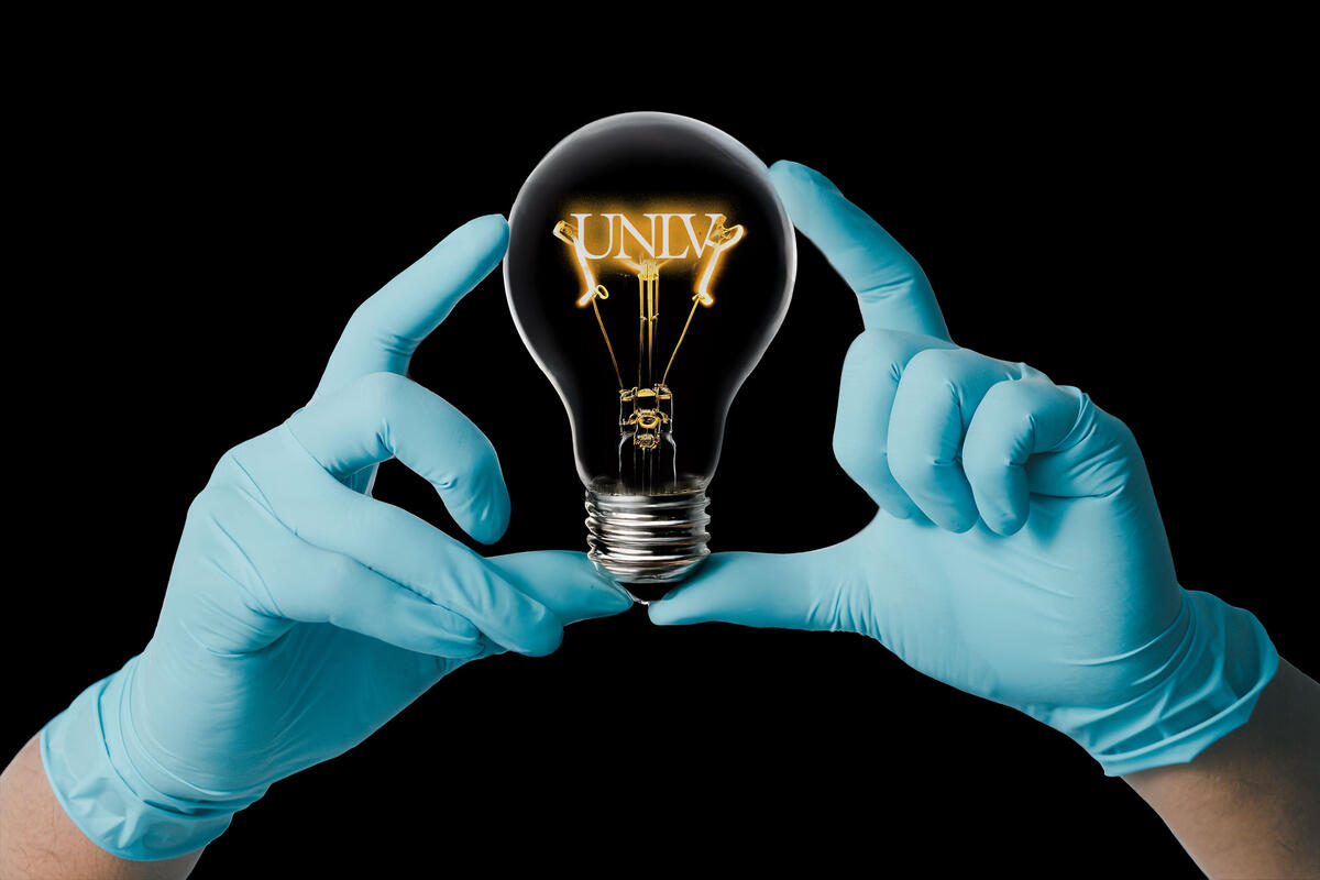 A doctor holding a light bulb with UNLV as the fillament