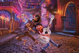 In this copyrighted image from Disney Pixar, Coco plays the guitar and dances with one of the elders in a scene direct from the film.