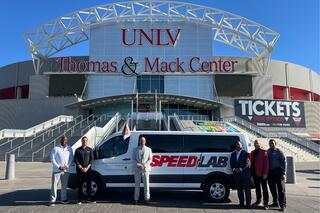 A group of faculty and community partners in front of the Sports Innovation Institute mobile SPEED Lab.