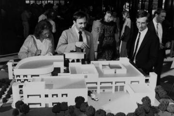archival photo of people looking at building model