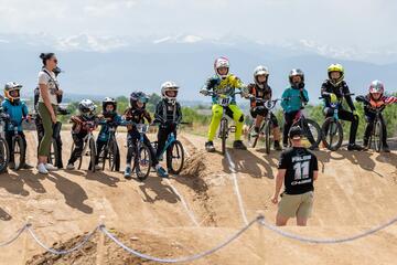 group of BMX riders atop bikes on sand dune
