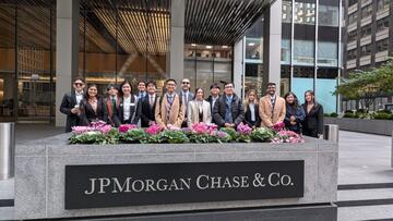 students pose behind a JP Morgan Chase & Co. sign