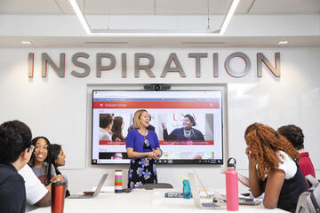 group at table during a marketing presentation and &quot;inspiration&quot; is written on the wall