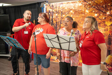 Mojave Counseling Day Treatment staff, Stuart Keller (far left) and Susanna Guarino (far right), participating in a music group activity with clients.