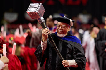 Satish Bhatnagar wearing graduation robes and holding ceremonial mallet