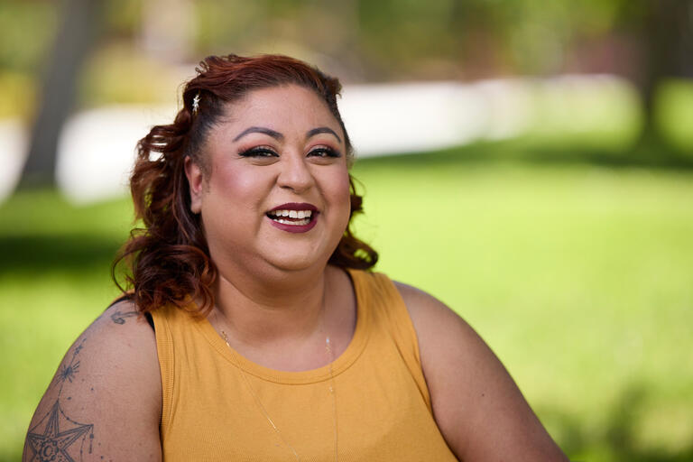 cropped photo of smiling woman in orange top