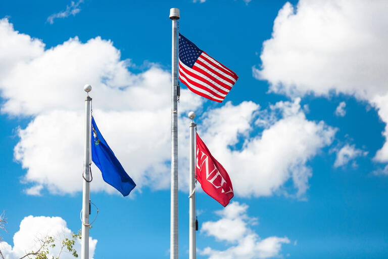 The U.S. flag, the Nevada state flag, and the UNLV flag.