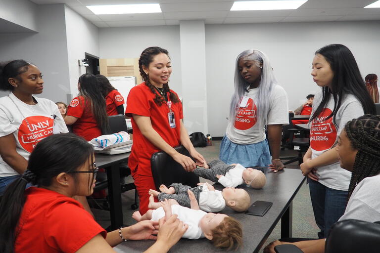 students working with infant manikins as part of nurse camp
