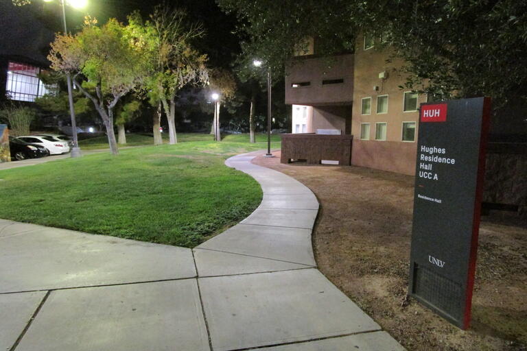 lamp posts on campus at night alight a sidewalk