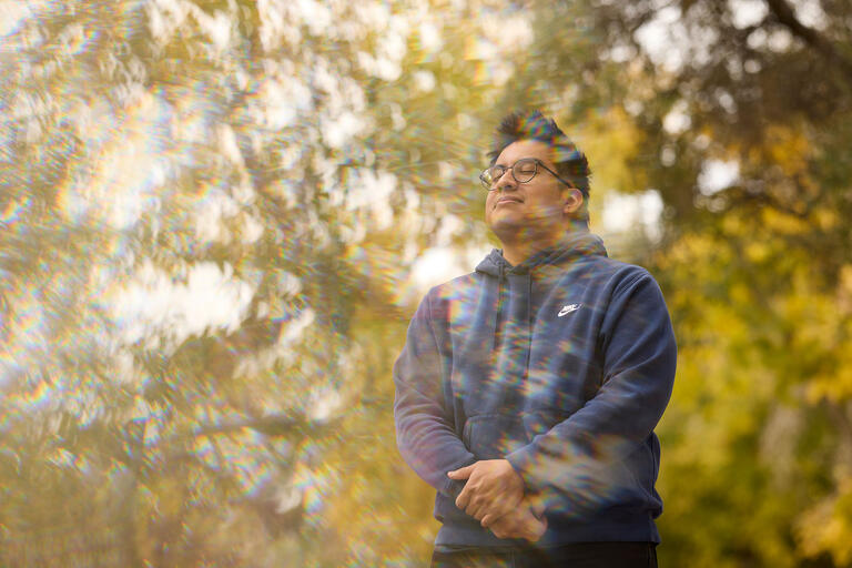 man photographed standing amidst fall foliage with a kaleidescope effect