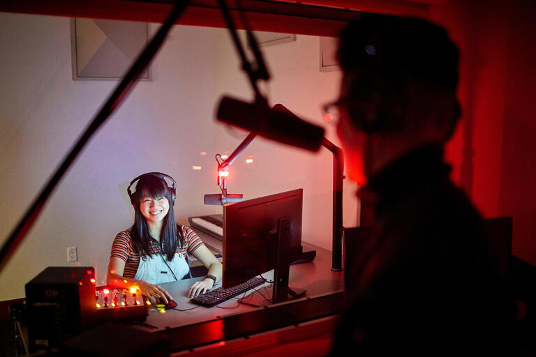 A woman in a recording booth.