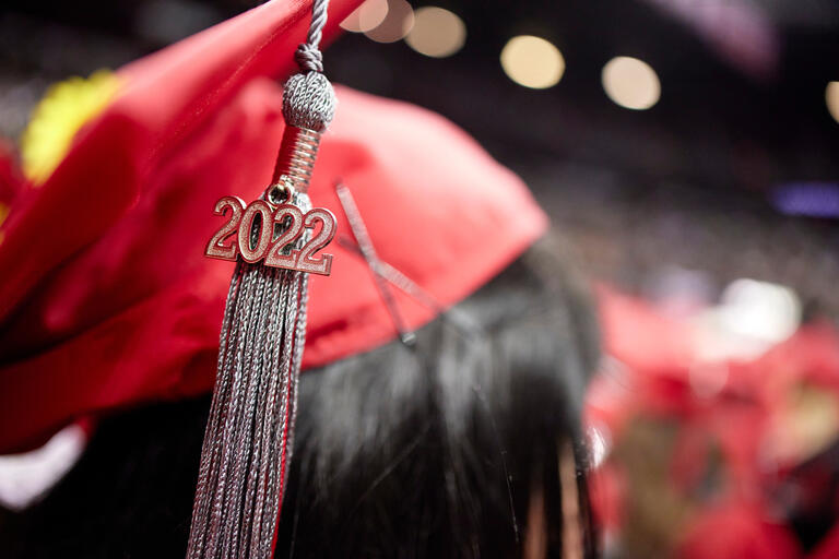 Close up of student wearing a red graduation cap with a 2022 tassel