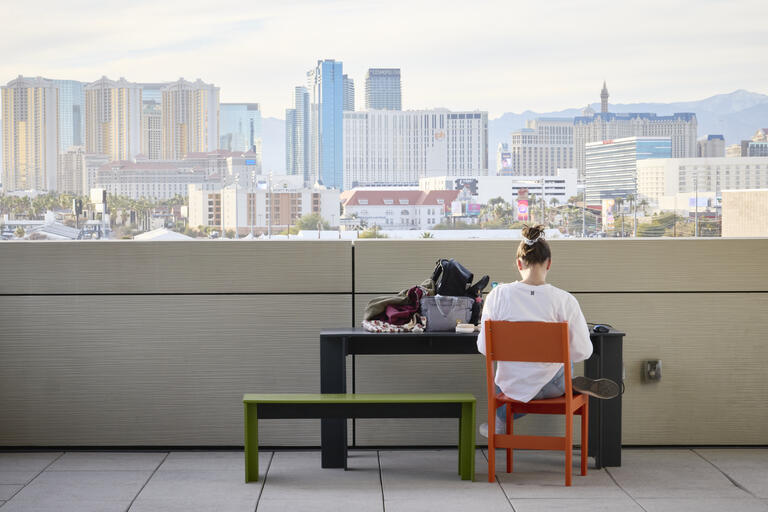 A UNLV student studies with the Strip in the distance.