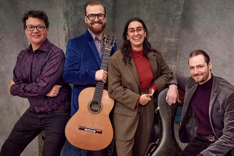 The Mela Guitar Quartet looks towards the camera, smiling in this promo photo.